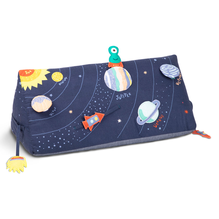 A blue baby wedge pillow with an outer space pattern